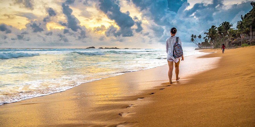 Vrouw wandelt op strand in Sri Lanka