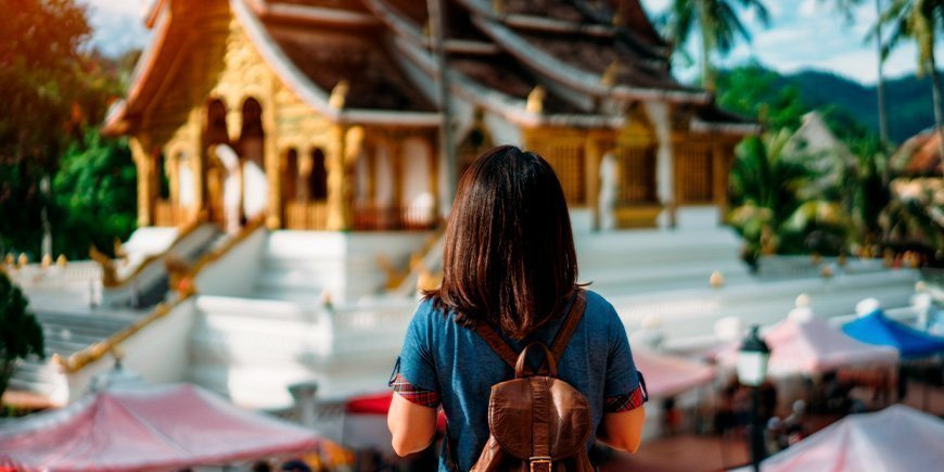 Vrouw kijkt naar tempel in Luang Prabang, Laos