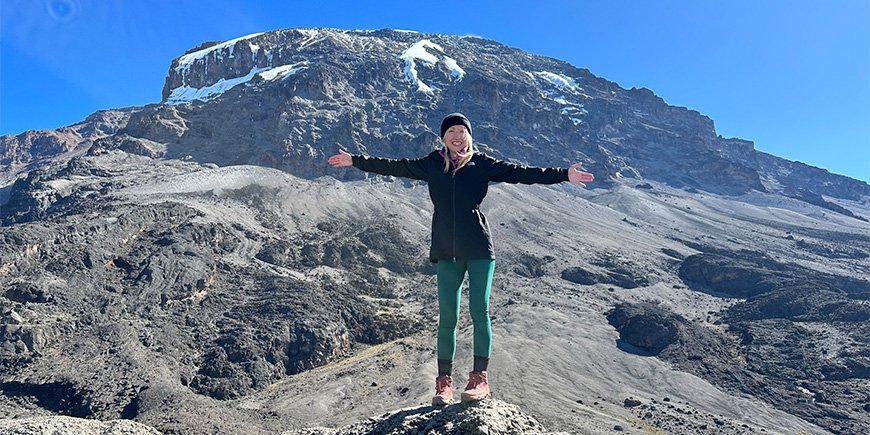 Catriona staand met uitzicht op de wilde landschappen van de Kilimanjaro