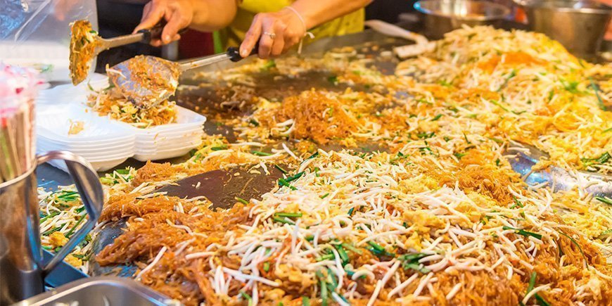 Pad Thai wordt bereid bij een kraampje in Thailand