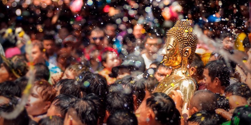 Gouden Boeddha wordt met water bespoten tijdens het Songkran festival in Thailand