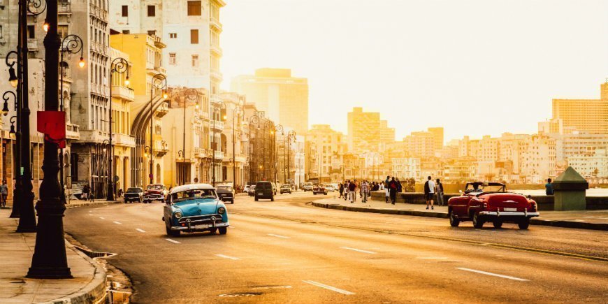 Auto's in een zonnige straat in Cuba