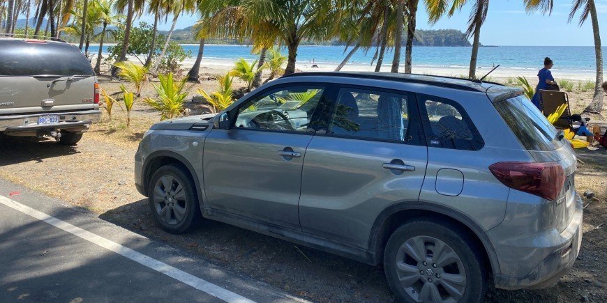 Auto geparkeerd naast prachtig strand in Costa Rica