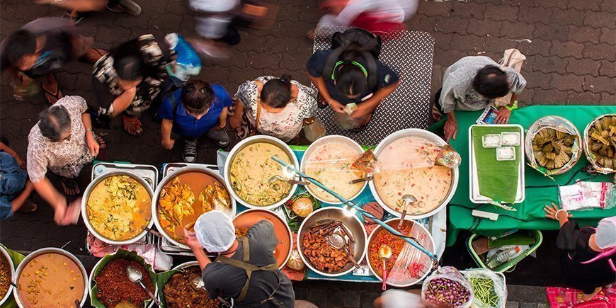 Mensen kopen eten op een markt in Thailand