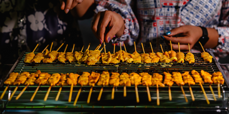 Vrouwen koken moo saté op de grill