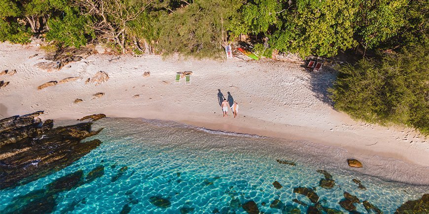 Koppels die elkaars hand vasthouden op het strand op Koh Samet