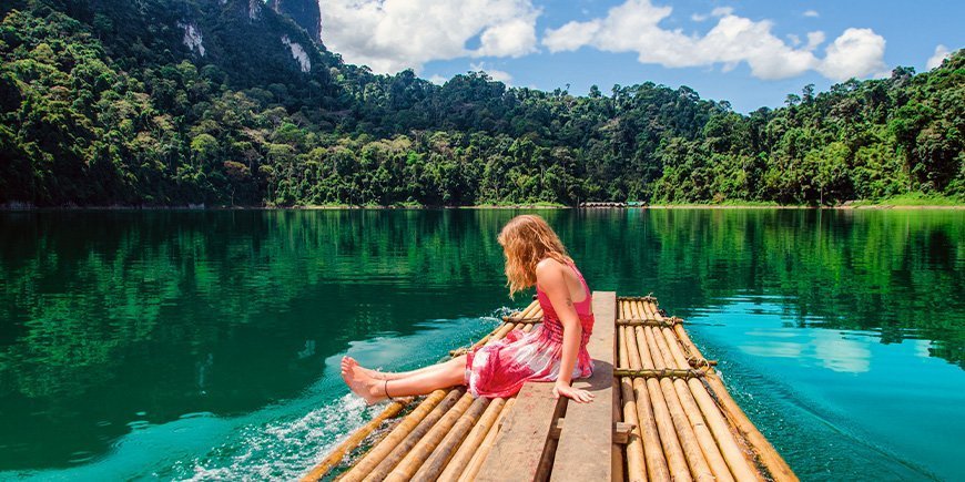 Jong meisje zittend bij het meer in Khao Sok National Park in Thailand