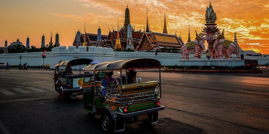 Tuk Tuk met uitzicht op een tempel in Bangkok