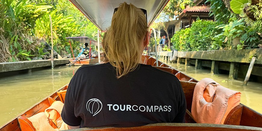 Vrouw in TourCompass t-shirt zittend in boot met haar rug gekeerd