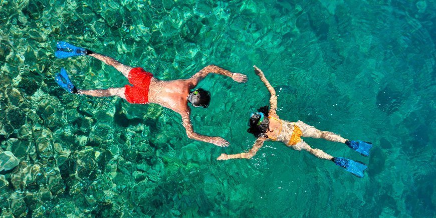 Koppel snorkelt in helder water in Thailand