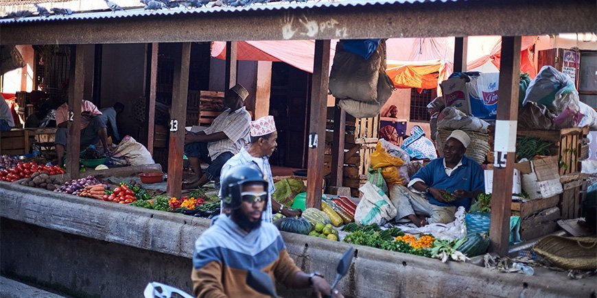 Mannen verkopen goederen op de markt in Stone Town