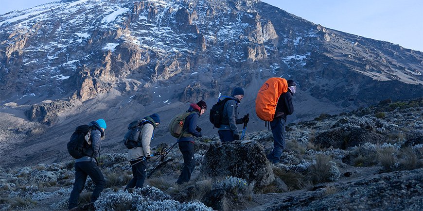 Familie loopt in een rij de Kilimanjaro op