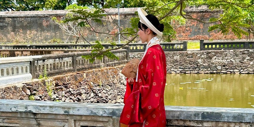 Vrouw gekleed in prachtige kleding in de keizerstad in Hué, Vietnam